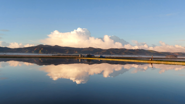Moutains and clouds reflected over a blue lake